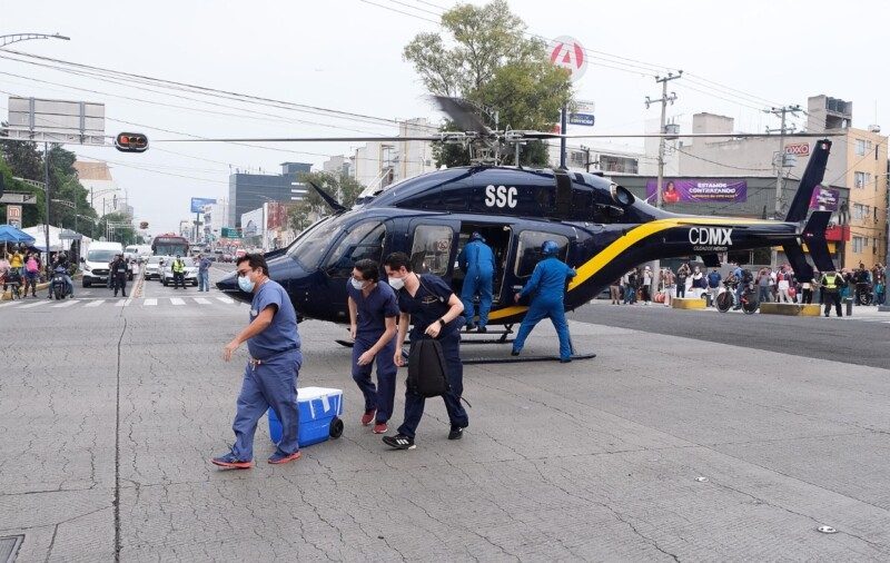 Personal médico trasladando contenedores desde un helicóptero