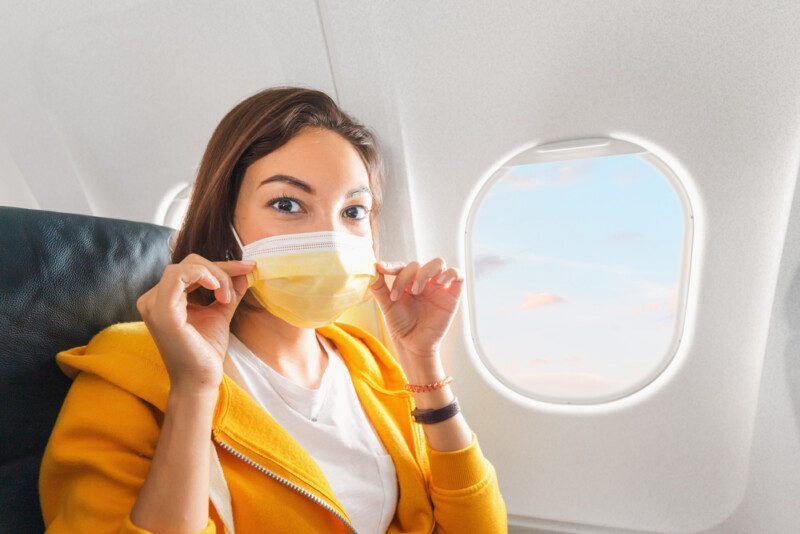 Una chica usa una máscara facial médica durante un vuelo