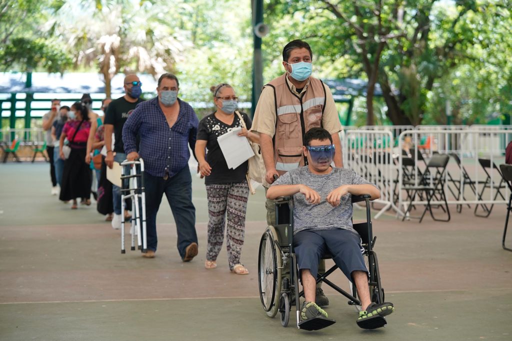 personas en fila para vacunación