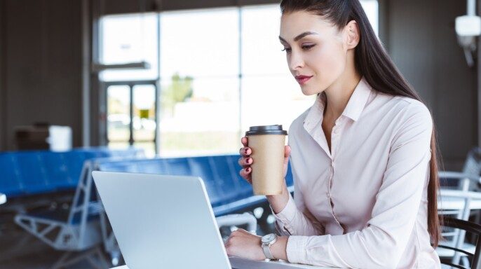 mujer de negocios con café usando el ordenador