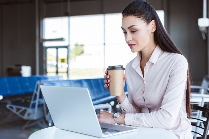mujer de negocios con café usando el ordenador