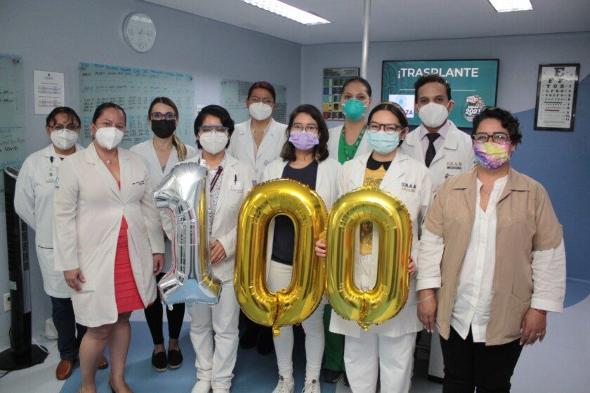 Personal del IMSS sosteniendo globos del número 100