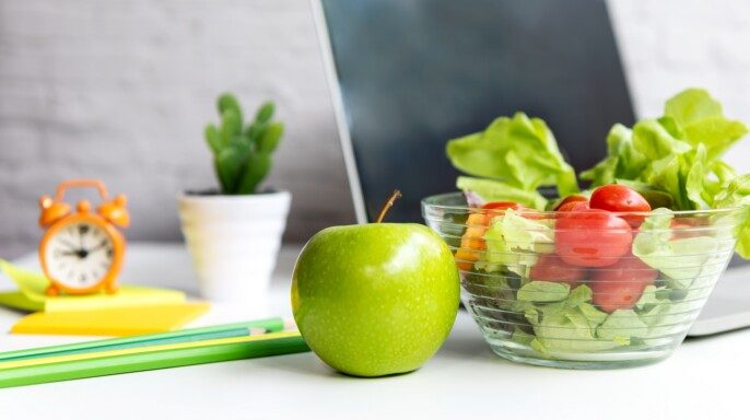 Snack saludable con trabajo en la oficina. Manzana verde y ensalada