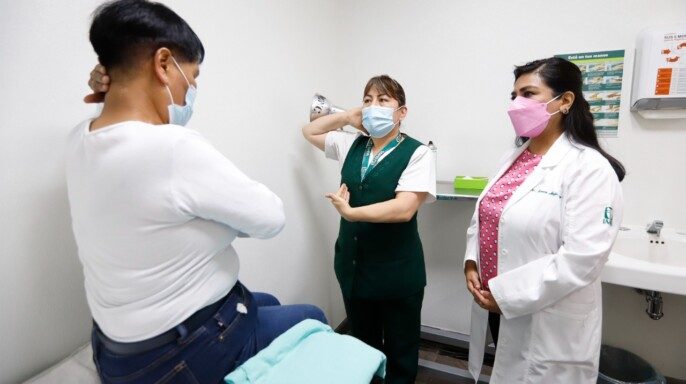 Enfermera capacitando a paciente en autoexploración mamaria
