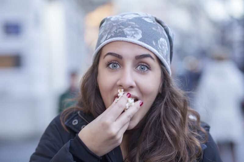 chica joven comiendo mientras camina