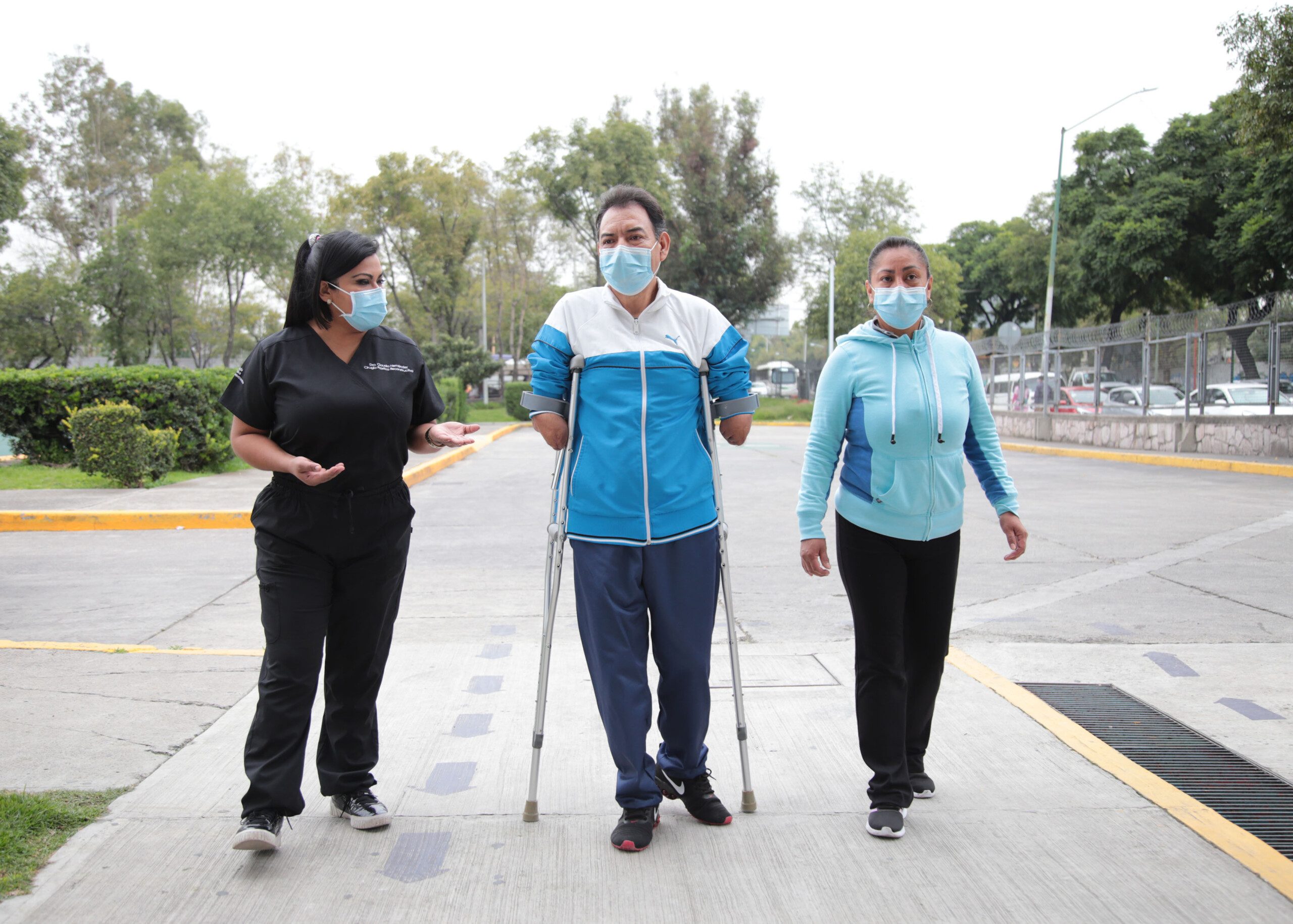 Paciente en muletas acompañado de 2 personas