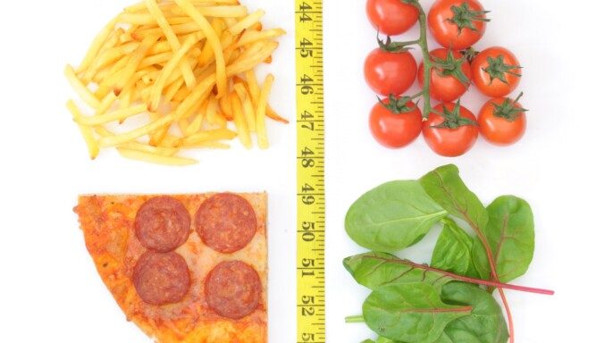 imagen de concepto elección saludable o poco saludable de un lado papas fritas y pizza en medico cinta de medir y del otro lado tomates y verduras