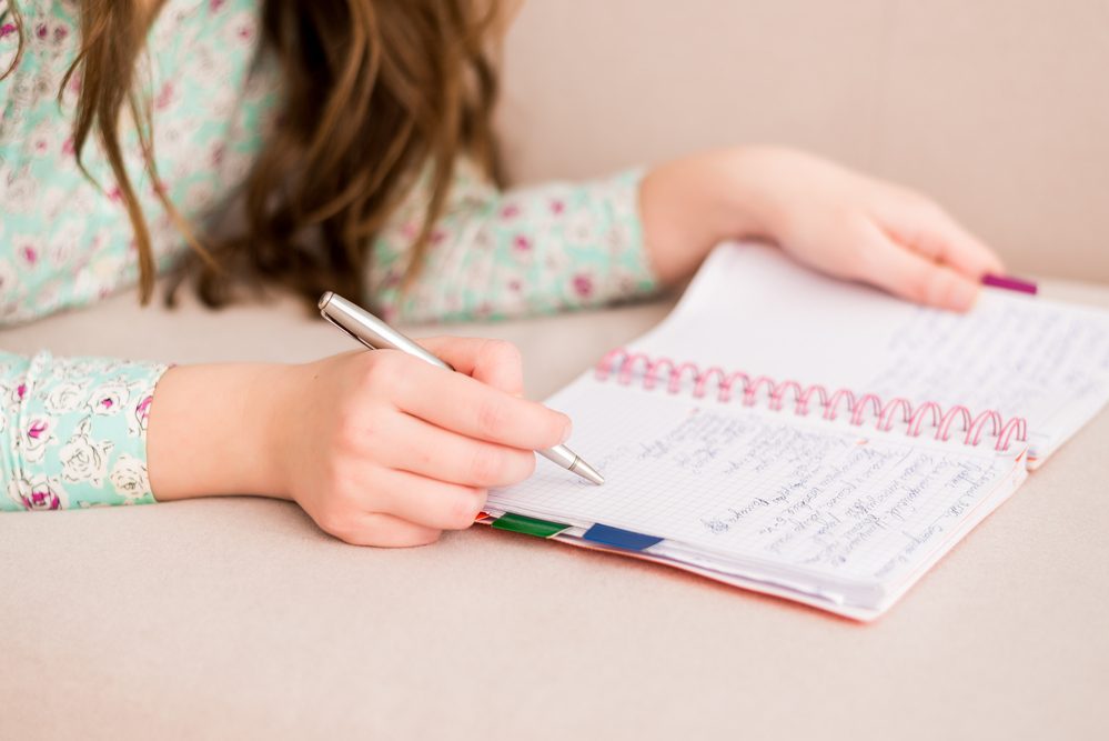 Primer plano de las manos de las mujeres escribiendo en un cuaderno