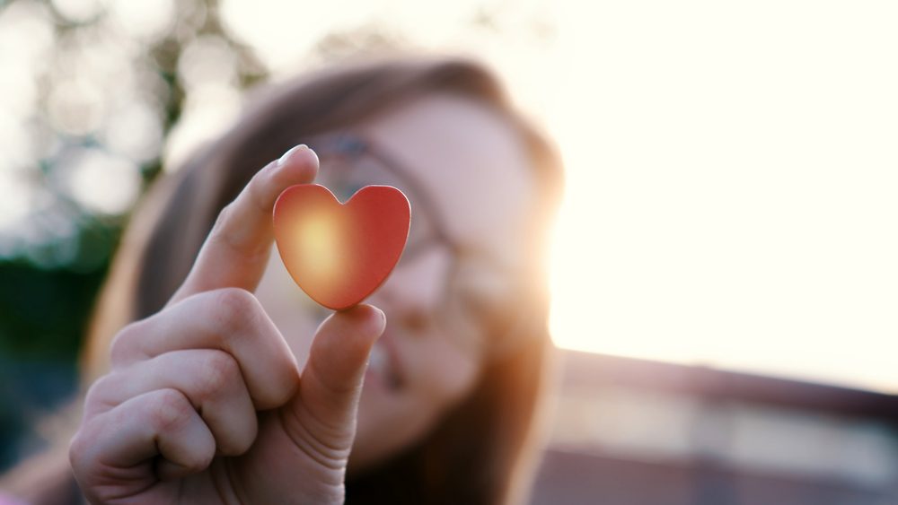 Forma de corazón en la mano de una hermosa joven