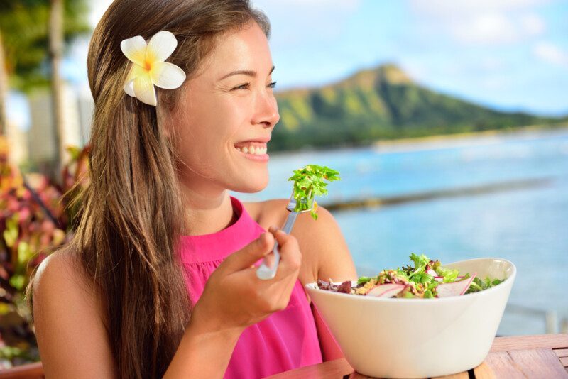 mujer comiendo en la playa