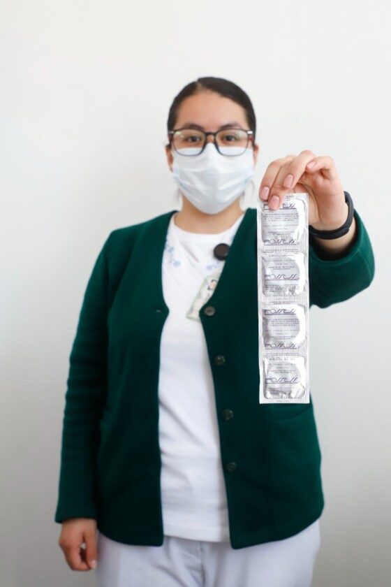 Enfermera sostiene tira de condones