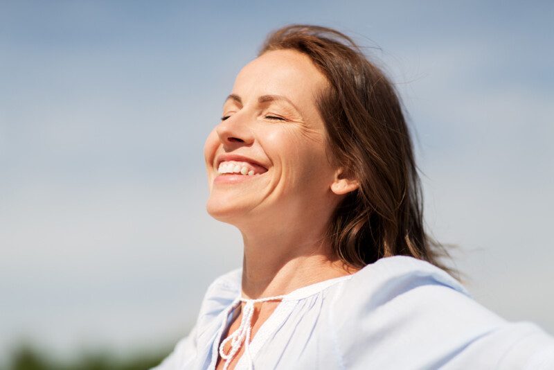 Feliz sonriente mujer disfrutando del sol