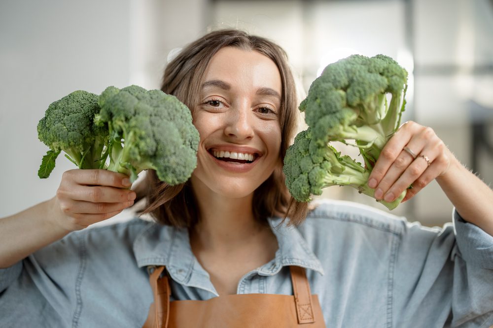 Vista recortada de niña sosteniendo coliflor y brócoli