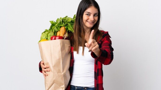 mujer Joven con verduras aisladas sobre fondo blanco