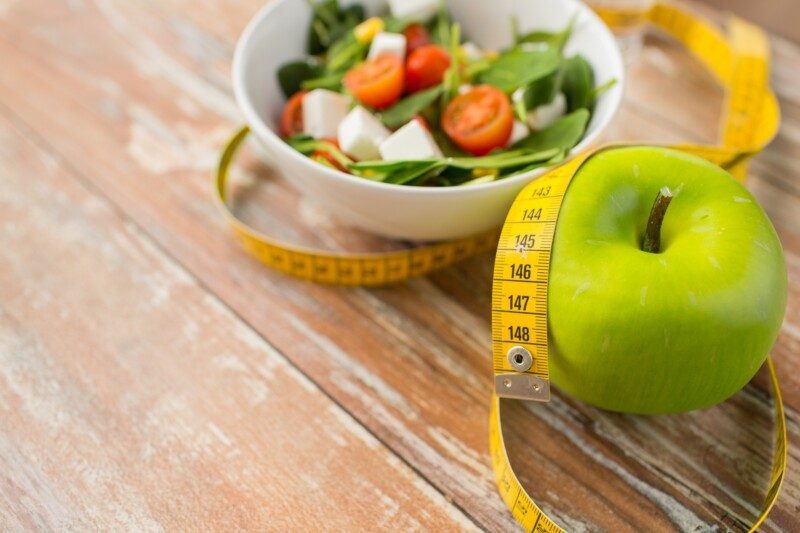 Primer plano de manzana verde y cinta métrica