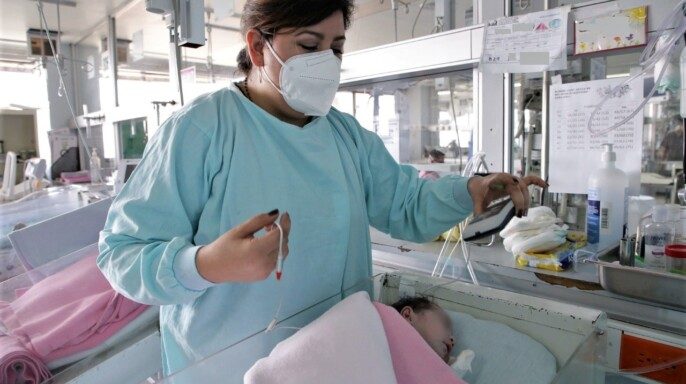 Enfermera aplicando Tamiz Auditivo Neonatal de Intervención Temprana en bebé