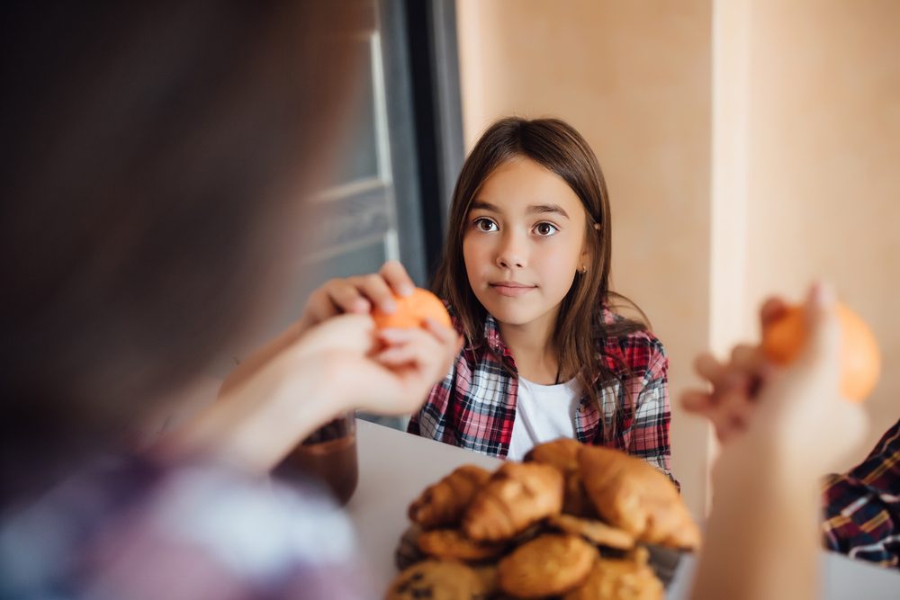 Fotos de Foto de la espalda, las manos de mamá dando un snack a su hija