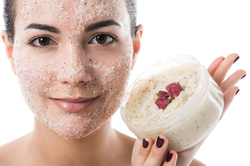 chica sosteniendo un tarro con crema exfoliante