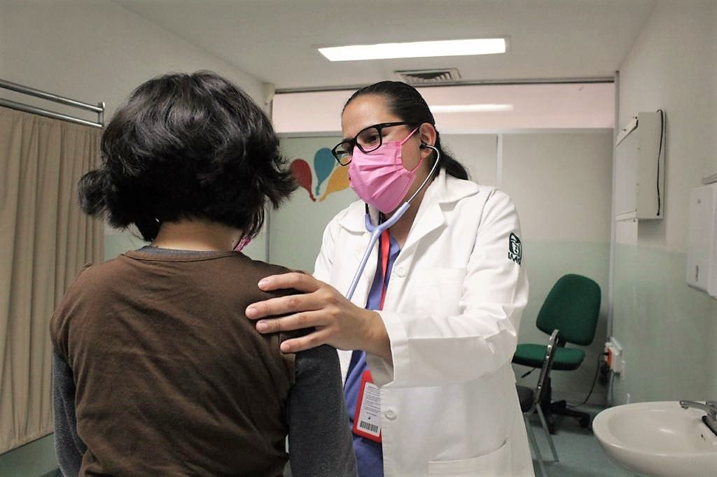 Médica del IMSS en consulta con infante