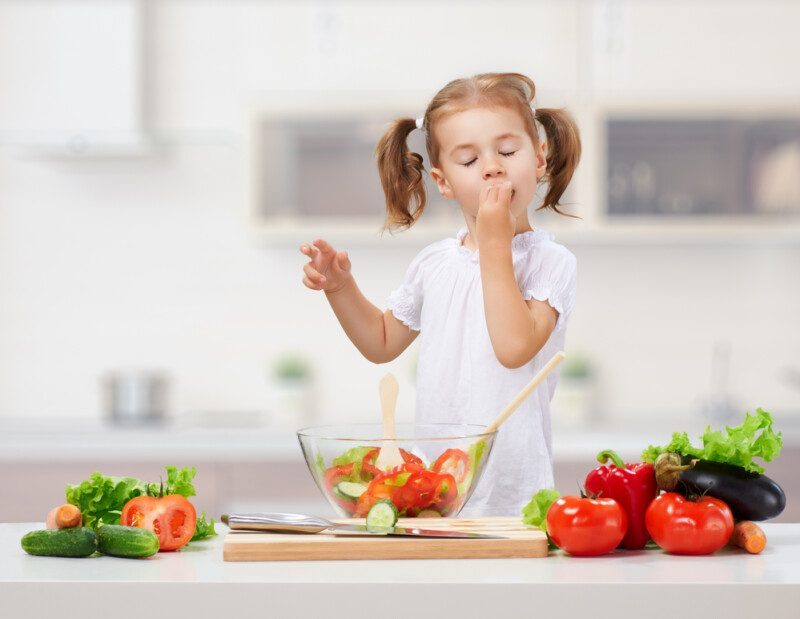 niña comiendo en la cocina