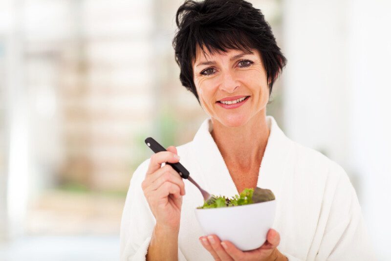 mujer madura comiendo una ensalada