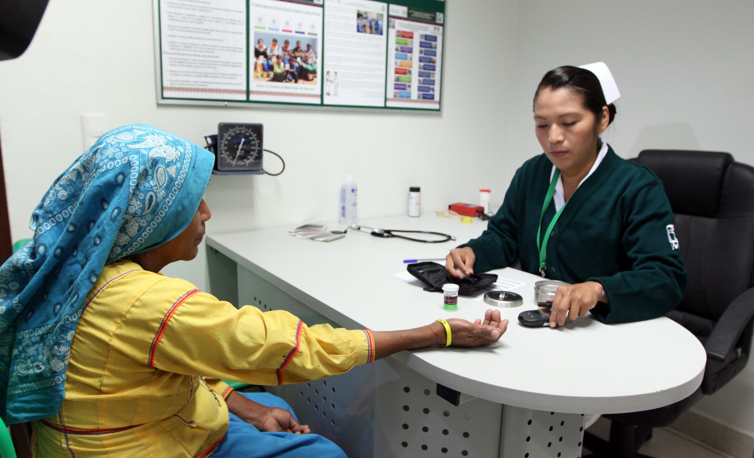 Enfermera del IMSS atendiendo a mujer