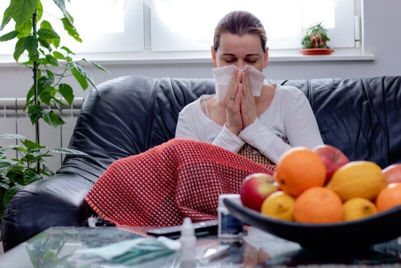 joven sentada enfrente de una charola de frutas