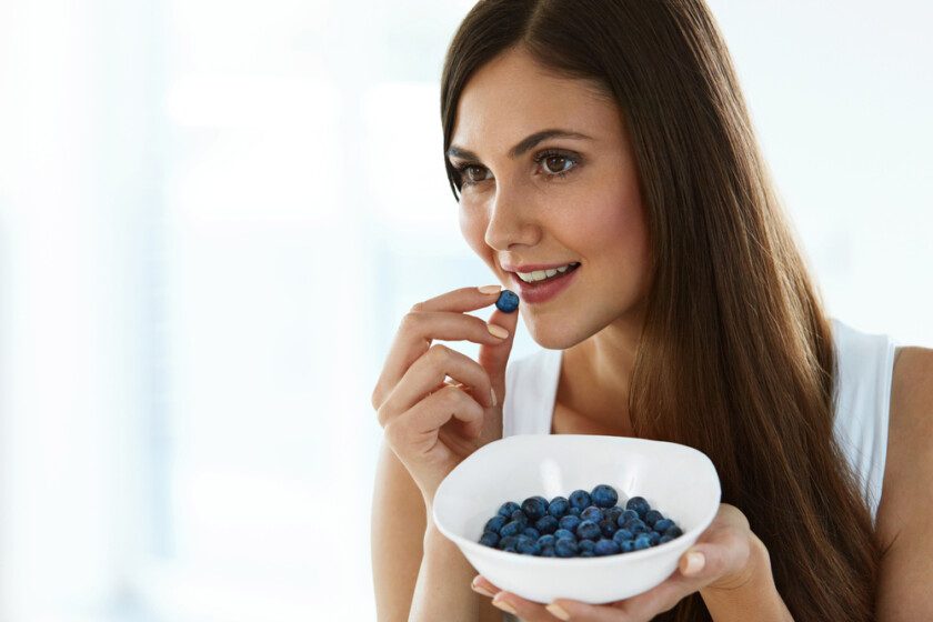 Comida saludable. Mujer feliz en la dieta Comer arándanos orgánicos — Foto de Stock Comida saludable. Mujer feliz en la dieta Comer arándanos orgánicos.