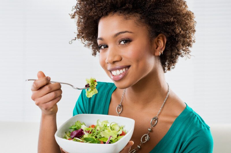 Mujer afroamericana comiendo ensalada