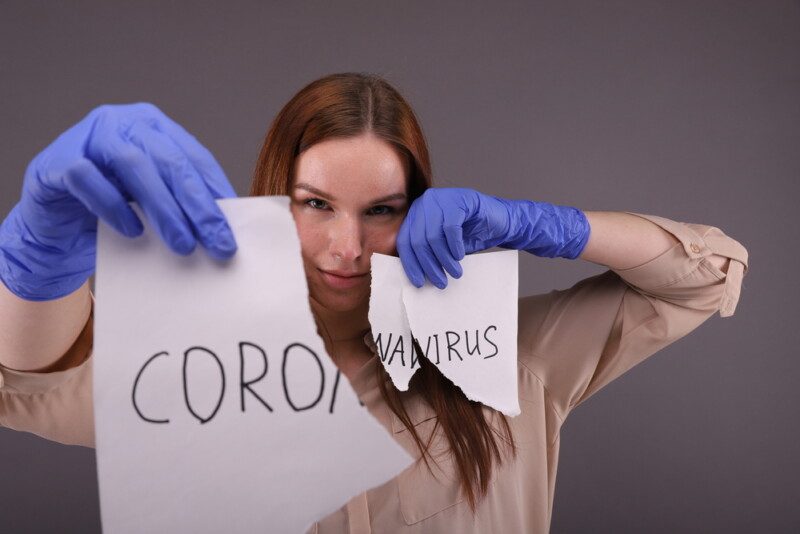 Mujer sosteniendo trozos de papel con signo "coronavirus".