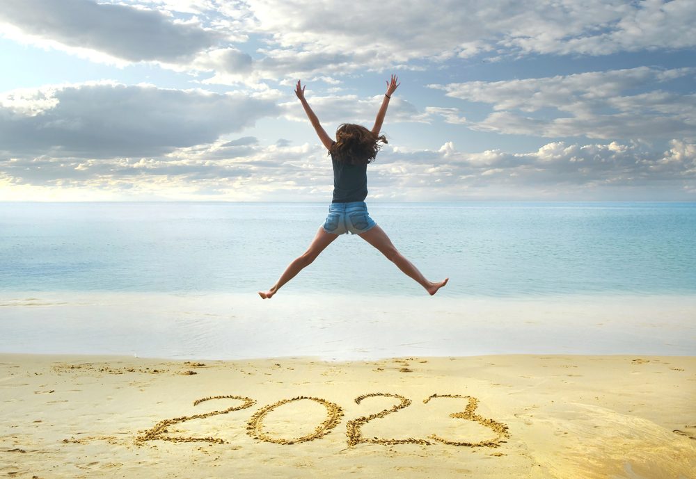 Año Nuevo 2023 Escrito Arena Chica Feliz Con Las Manos — Foto de Stock Año Nuevo 2023 escrito en la arena, chica feliz con las manos arriba.