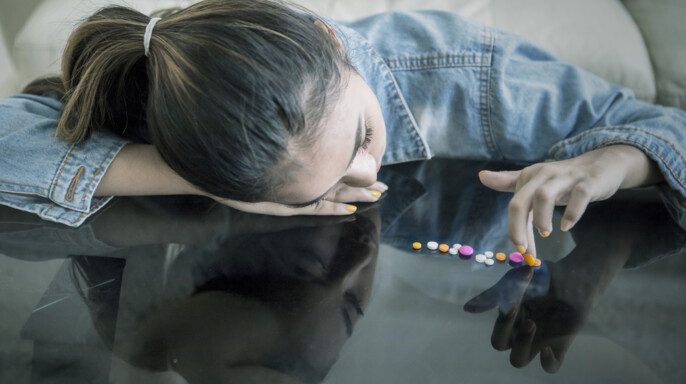 Adolescente femenina contando drogas en la mesa.