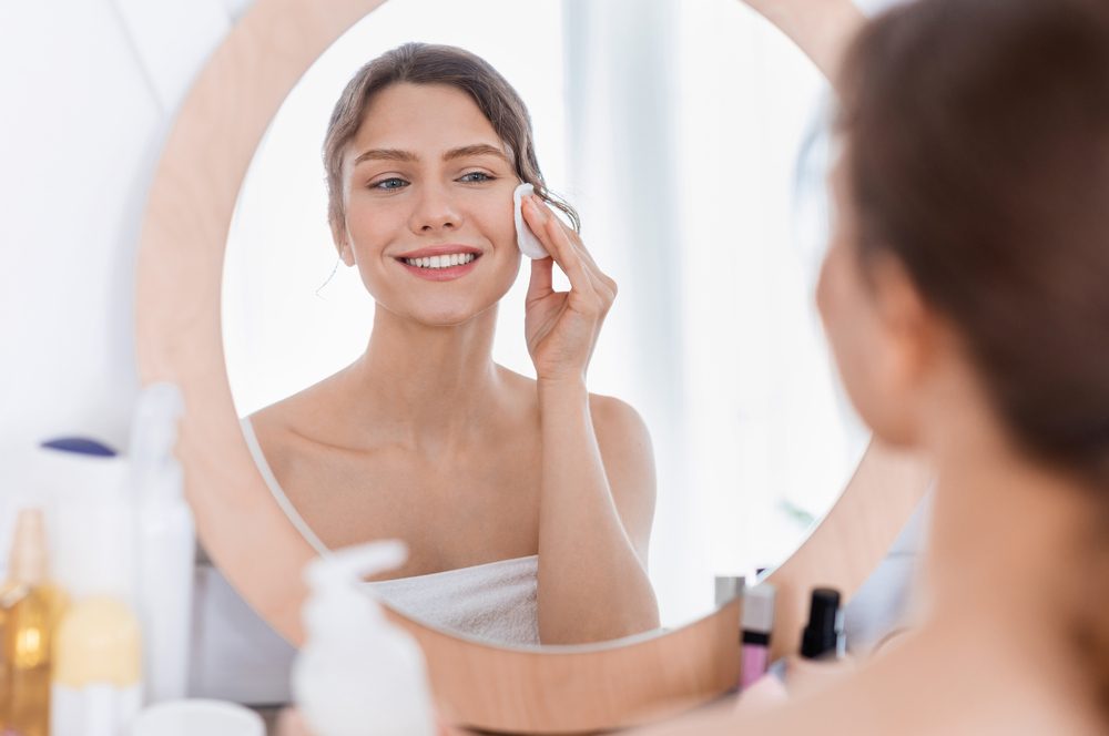 Chica de aspecto fresco usando almohadilla de algodón, procedimientos de limpieza por la mañana — Foto de Stock Chica de aspecto fresco usando almohadilla de algodón