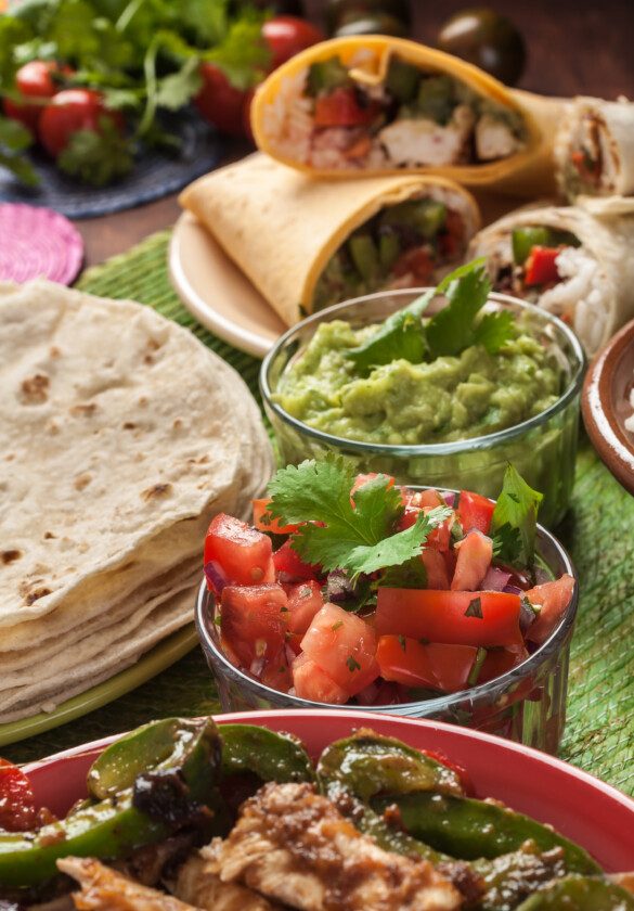 comida tradicional mexican: cilantro y lima arroz, fajitas, fajita peppers, burritos, tortillas, guacamole y salsa