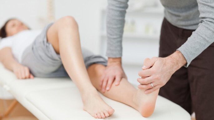 Fisioterapeuta estirando un pie descalzo