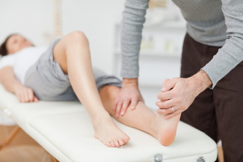 Fisioterapeuta estirando un pie descalzo