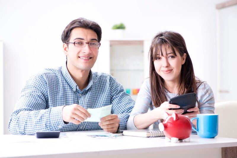 Pareja joven mirando los papeles de finanzas familiares — Foto de Stock Pareja joven mirando los papeles de finanzas familiares.