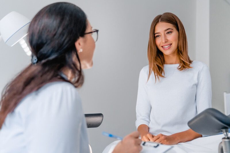 Ginecóloga hablando con paciente joven durante consulta médica