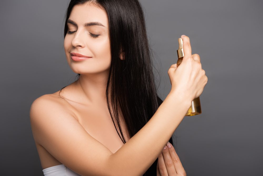 Morena Mujer Rociando Aceite Pelo Aislado Negro — Foto de Stock New Borrar fondo Guardar Compartir Muestra Morena mujer rociando aceite en el pelo aislado en negro