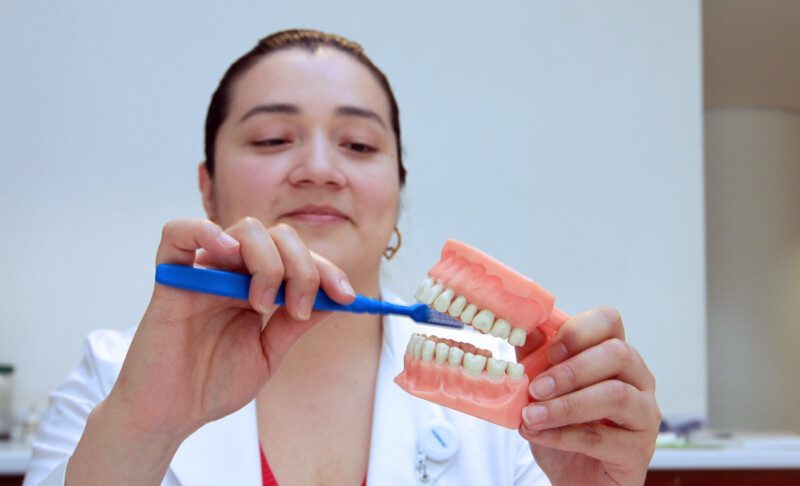 Especialista en salud demostando cepillado de dientes