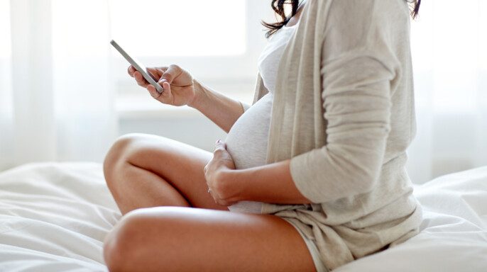 primer plano de mujer embarazada con celular