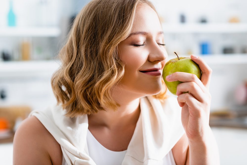 Mujer Joven Con Los Ojos Cerrados Oliendo Manzana Verde — Foto de Stock New Borrar fondo Guardar Compartir Muestra Mujer joven con los ojos cerrados oliendo manzana verde