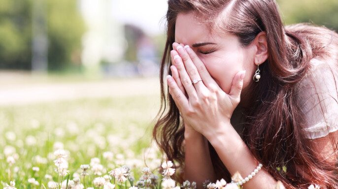 Chica estornudando en un campo de flores — Foto de Stock New Borrar fondo Guardar Compartir Muestra Chica estornudando en un campo de flores