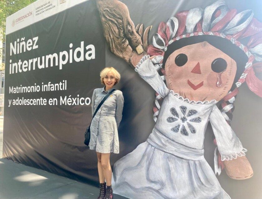 Ximena Gabriela Pérez Dorantes con su obra "Arrebato", que es la portada del libro Niñez interrumpida, matrimonio infantil y adolescente en México.