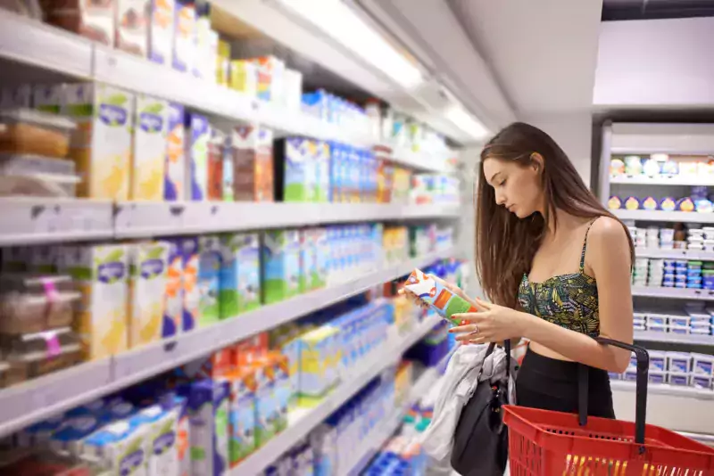 Mujere comprando y revisando por grasas trans industriales