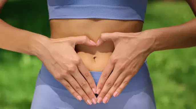 Mujer haciendo signo de corazón para prevenir las enfermedades digestivas